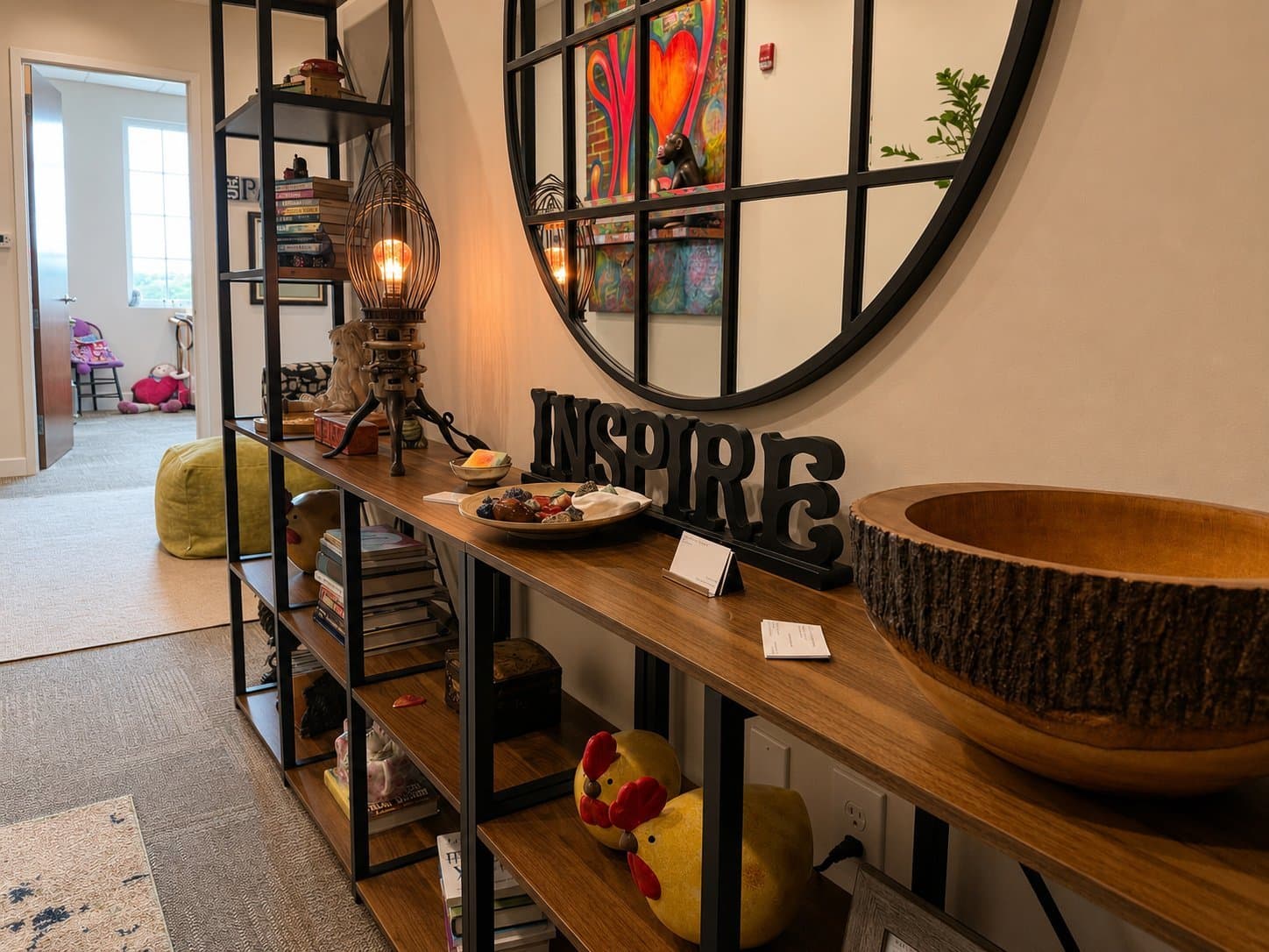 Entry console with the word Inspire and a round mirror