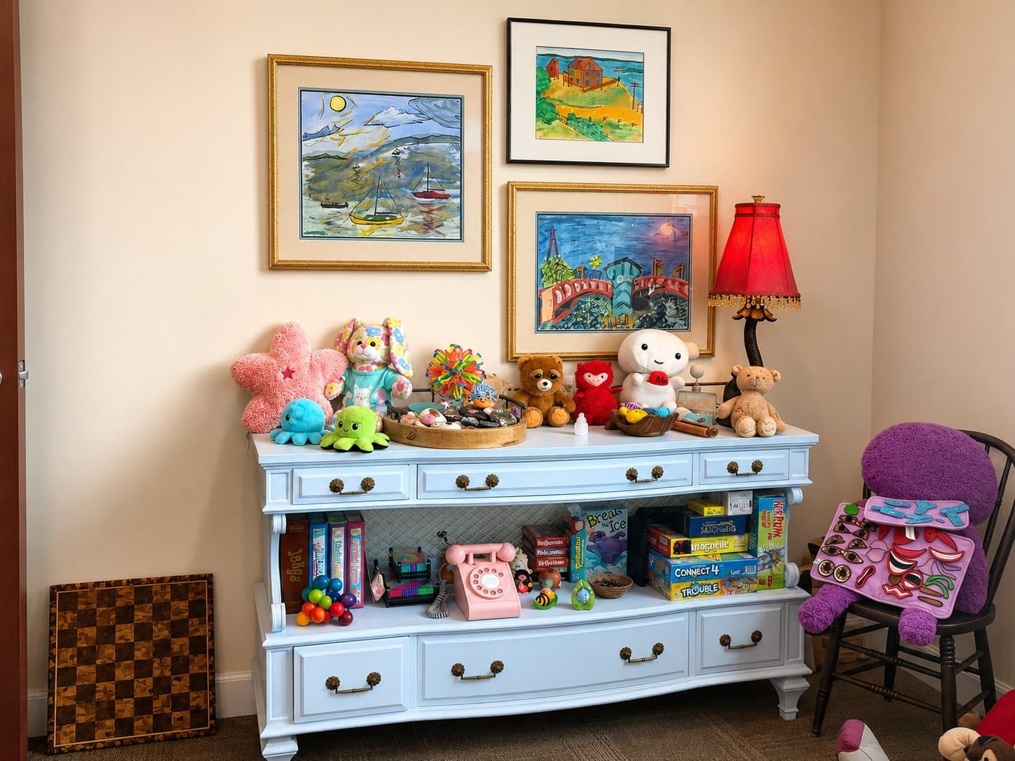 Stuffed animals, games, and play therapy materials on a blue dresser